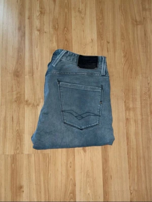 Replay blå jeans straight fit - Säljer ett par blå jeans från Replay med klassisk femficksdesign och raka ben. Jeansen har en snygg tvättad look och detaljerade sömmar på bakfickorna. Passformen är straight och materialet är slitstarkt denim. Perfekt för dig som gillar stilrena och tidlösa jeans.