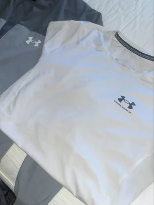 Ingen sko syns på bilden - Bilden visar inga skor, endast kläder från Under Armour. Kan inte ge någon skobeskrivning.