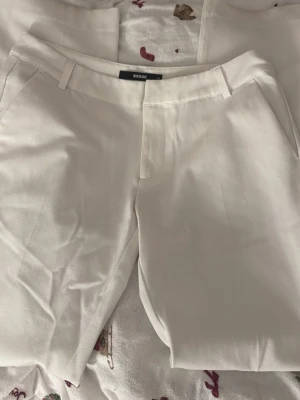 Vita kostymbyxor - Jättesnygga kostymbyxor från BikBok i modellen Vera. Säljer då de ej kommer till användning då de är för stora och långa för mig. (därav fläckarna nere vid fötterna, som jag ej provat få bort men skulle säkert gå med galltvål eller liknande)