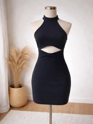 Zara klänning – Nytt skick – Storlek S - Elegant och figurnära klänning från Zara i klassisk svart färg. Modern design med öppen rygg och stilren detalj framtill – perfekt för fest, middag eller kvällsevenemang.  Detaljer: 	•	Storlek: S 	•	Skick: Ny (ej använd) 	•	Färg: Svart 	•	Material: Polyester,Elastan