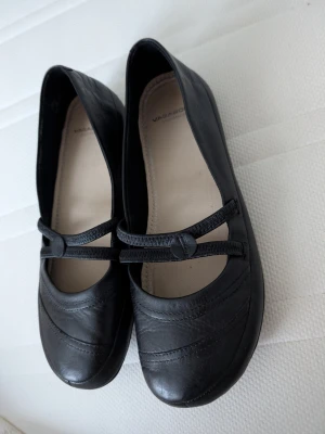 Vintage ballerinaskor från Vagabond - Klassiska svarta ballerinaskor från Vagabond i skinn med rund tå och dekorativa dubbla remmar över foten. Snyggt mönstrad sula och enkel, stilren design som passar till det mesta. Perfekta för dig som gillar tidlösa och bekväma skor. Köpta tidigt 2000 tal, oanvända 