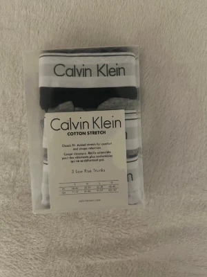 Calvin Klein kalsonger (svart,grå och vit) - Kalsonger från Calvin Klein med tydlig svartvit logga på bröstet. Västen har en klassisk form och är tillverkad i mjuk bomull med stretch för extra komfort. Perfekt för dig som gillar stilrena och enkla plagg med tydlig branding.