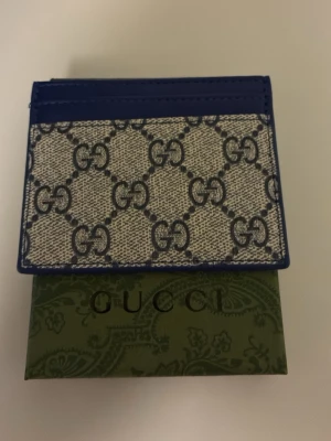 Beige plånbok med blåa G - Säljer en helt ny plånbok låda inkluderat i köp