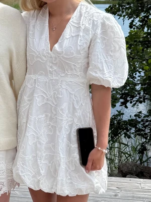 Vit studentklänning med brodyr  - Superfin vit studentklänning med brodyr, v-ringning och puffärmar! Endast använd på midsommar, från märket majive 💕 i nyskick och har dragkedja på sidan! I superbra kvalitet💕 passar mig som är 165⭐️PERFEKT  till studenten och säljs inte längre 