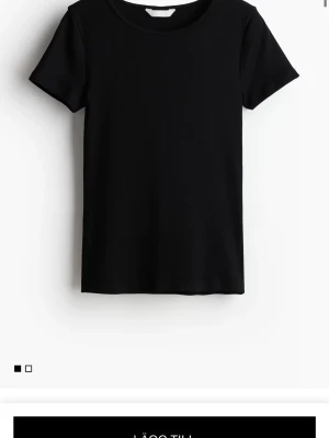Svart ribbad t-shirt - En stilren svart t-shirt med ribbad struktur och rund hals. Klassisk passform och korta ärmar, perfekt att matcha med allt. Tillverkad i mjukt material som känns skönt mot huden.