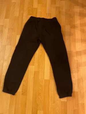 Svarta mjukisbyxor från Champion M - Svarta mjukisbyxor från Champion i storlek medium. Byxorna har resår i midjan med vit dragsko och muddar vid bensluten. Tillverkade i en mjuk bomulls- och polyestermix. Champion-logga broderad på ena benet. Perfekta för chill eller träning.passar 160-165,villig att gå ner i pris