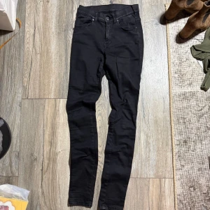 Svarta skinny jeans från Dr Denim - Säljer ett par svarta skinny jeans från Dr Denim med hög midja. Jeansen är tillverkade i stretchigt material för en tight och bekväm passform. Perfekta till sneakers eller boots och funkar året runt. ‼️ obs att en söm på ena fickan har gått upp, se bild 