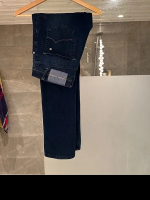 Jacob Cohén jeans  - Mörkblå jeans från Jacob Cohen, limited edition style 620. Klassisk femficksmodell med kontrastsömmar och en liten broderad blomma på bakfickan. Snyggt läderpatch med logga i midjan och broderade detaljer på insidan. Perfekt för dig som gillar exklusiva jeans med unika detaljer.