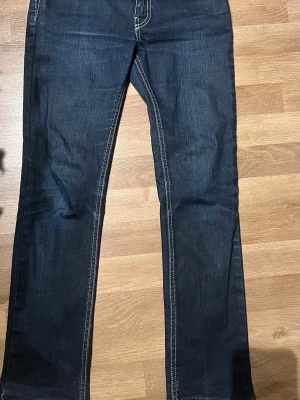 Levi's 512 mörkblå jeans - Säljer ett par Levi's 512 jeans i mörkblå tvätt med kontrastsömmar. Klassisk femficksmodell med raka ben och snygg passform. Tillverkade i Italien av stretchig denim för extra komfort. Perfekta till sneakers eller boots.