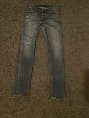 Blå jeans från neuw - Säljer ett par riksfeta jeans från Neuw med en skön sliten design i bra skick. Dem är i storlek 29/32 i en slim fit. Knappen vid midjan är dock lite lös men inte så märkvärdigt. Kom dm för mer info!