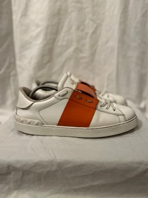 Valentino opens  - Riktigt feta valentino opens i storlek 42,5. Mycket bra skick. Vita skor med orange färg i mitten. Passar till allt! Storleken sitter lite smått. Skriv för fler frågor🙏🏼