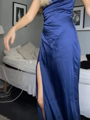 Marinblå axelbandslös långklänning - Säljer denna jättefina axelbandslösa mörkblå balklänningen i satin/glansigt material från Nelly. Hade den på min studentbal och är använd 2 gånger endast. Köptes för 800 kr💞