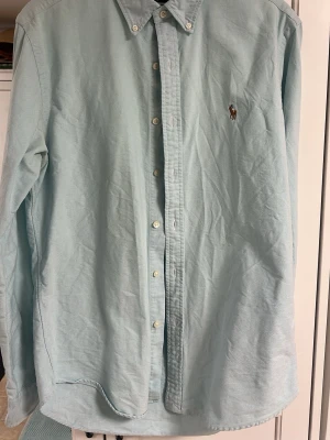Ljusblå ralph lauren skjorta - Fet turkos/ljusblå skjorta från raffe, fint skick passar bra till chinos eller linnebyxor