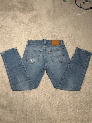 Levi's 511 ljusblå jeans W30 L30 - Säljer ett par klassiska Levi's 511 jeans i ljusblå tvätt. Modellen har slim passform, fem fickor och ikonisk läderpatch bak. Endast ett litet hål i vänstra bakfickan . Perfekta för en avslappnad look.