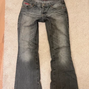 gråa lågmidjade bootcut jeans - säljer dessa jättesnygga jeans då de inte kommer till användning något mer, inga defekter förutom att de är lite slitna längst ner men det syns knappt (sista bilden) midjemått är 40cm, Innerbenslängd 79cm och grenmåttet är 17cm! de sitter ganska långt ner på midjan. PRIS KAN DISKUTERAS💕skriv för frågor!