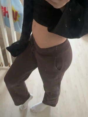 Bruna mjukisbyxor  - Mörkbruna mjukisbyxor med ribbad midja och snörning. Byxorna har raka ben och sidofickor, perfekta för chill dagar. Tillverkade i mjukt bomullsmaterial för extra komfort. 