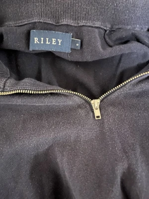 Quarter Zip tröja - Mörkblå långärmad tröja från Riley i storlek S. Tröjan har en klassisk half zip-dragkedja framtill och hög krage. Tillverkad i mjukt bomullsmaterial som är skönt mot huden. Perfekt för en skön inomhuströja nu när det är kallt.