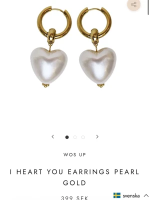 Hjärtformade pärlörhängen i guld - Snygga örhängen från WOS med hjärtformade pärlor i vitt och guldfärgade hoops. Perfekta för dig som vill ha en söt och trendig accessoar med en lyxig känsla. Materialet är metall och pärlimitation.