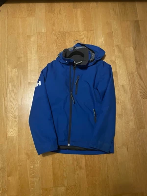Helly Hansen - Säljer denna feta Helly Hansen jacka i bra skick två fläckar som syns på sista två bilderna men som går bort vid tvätt det är storlek 164/14 fits XS passar dig mellan 164/170 hör av er vid minsta fundering fraktar samma dag som köp!