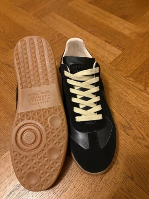 Svarta sneakers från Maison Margiela - Stilrena svarta sneakers från Maison Margiela . Storlek 44 , påse och box tillkommer
