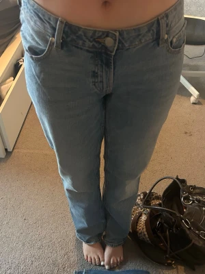 Lågmidjade jeans - Säljer ett par ljusblå jeans med rak passform och lågmidja. Klassisk femficksmodell i mjuk bomullsdenim, perfekta till en avslappnad stil. Inga synliga detaljer som slitningar eller mönster, bara clean och enkel look. Jag har använt dem en gång. 