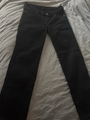 Svarta lågmidjade jeans från dr. Denim - Säljer ett par svarta lågmidjade jeans från dr. Denim. Jeansen är tillverkade i mjukt bomullsmaterial med lite stretch för extra komfort.