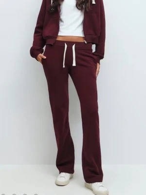 Vinröda mjukisbyxor med snörning - Mysiga vinröda mjukisbyxor med vita snören i midjan och bootcut.. Perfekta för chill dagar eller när du vill vara bekväm men ändå se snygg ut. Tillverkade i mjukt material och har en relaxed passform.