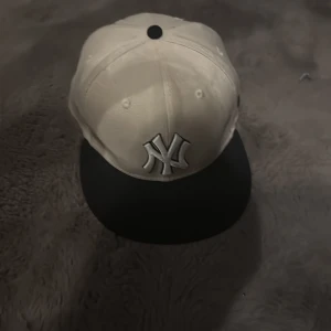 New Era Yankees keps vit och svart - Snygg New Era 59FIFTY keps i vitt med svart skärm och broderad New York Yankees-logga framtill. Klassisk rak skärm och strukturerad passform. Perfekt för dig som gillar streetwear och sportig stil.