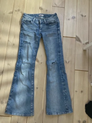 Blå jeans från Gina Tricot med broderi - Snygga blå jeans från Gina Tricot med dekorativa broderade bakfickor . Inga täcken på slitage🩷