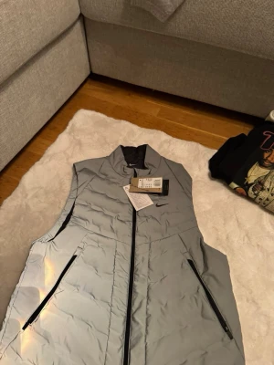 Nike jacket  - Alright! Here's a more detailed description for the Nike vest:  Description:  I'm selling a brand-new, unworn Nike vest, still with the original tags attached. This stylish vest is in a versatile gray color, making it a great addition to any wardrobe. It's perfect for the spring season, offering both style and functionality. The vest is in pristine condition, never been worn, and ready for a new owner.  Price: 1400 SEK, but I'm open to reasonable offers.  Key Features: *   Brand: Nike *   Condit
