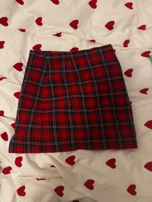Röd rutig kjol  - Kjolen har inga defekter och är använd 1 gång. Står att det är en medium men passar på mig som vanligtvis har xs. Midjemått: 30cm