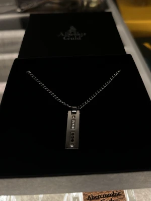 Silverhalsband från Albrekts Guld - Snyggt silverhalsband med en rektangulär hängande bricka, dekorerad med tre små klara stenar i rad. Kedjan är tunn och stilren, perfekt för dig som gillar minimalistisk design. Kommer i originalask från Albrekts Guld. Priset är inte satt i sten än så kom med bud👍