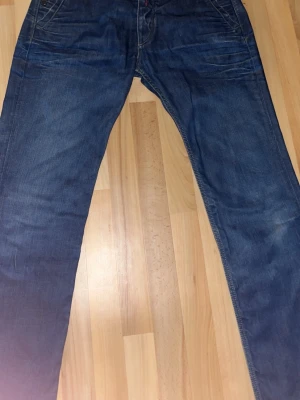 ReplayJeans W34 – Lined Denim - Snygga Replay-jeans i storlek W34. Mörkblå denim med fodrad insida och chinos-inspirerade fickor för en clean, modern look.  Replay nummer #947 Mycket bra sick   Pris kan diskuteras  ✔ Äkta Replay ✔ W34 ✔ Knappgylf ✔ Smart casual / streetstyle 