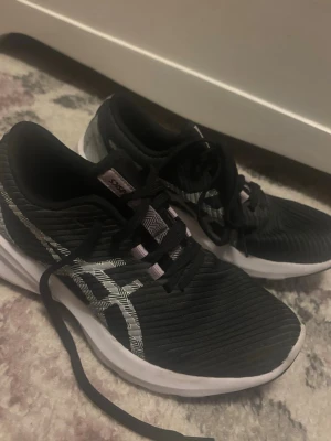 Svarta Asics sneakers med vit sula - Snygga svarta sneakers från Asics med vit sula. Använda inomhus ett fåtal gånger🌸