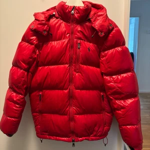 Röd Ralph lauren pufferjacka storlek S - Tja! Säljer nu min Ralph lauren jacka i den unika röda färgen. Jackan har inga defekter utan är bara använd sparsamt. Jackan är i storlek S och nypris är cirkus 6000kr, mitt pris är 2499! Hör av dig vid frågor och funderingar!