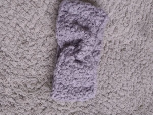 Grått handgjort virkat pannband - Snyggt och brett virkat pannband i ljusgrått som jag gjort själv. Pannbandet har en twistad detalj framtill. Perfekt för att hålla öronen varma och samtidigt se trendig ut under kyliga dagar.