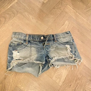 Blå slitna jeansshorts med fransar - Lågmidjade jeansshorts med slitningar
