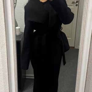 Svart kappa  - Kort kappa med bredare krage från Vero Moda. Går både att knäppa och knyta. Använd några gånger. Lite nopprig under ärmarna, men går att få bort med maskin. 