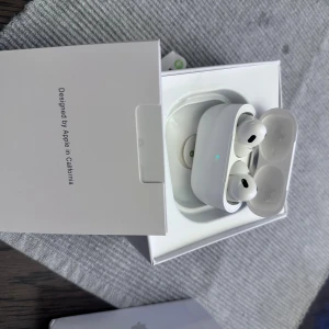 AirPods Pro - Säljer ett par AirPods Pro i originalförpackning. Hörlurarna är i mycket fint skick, ser ut som nya och levereras med laddningsetui. Perfekt för trådlös musik och samtal med aktiv brusreducering. Inga synliga defekter eller slitage.