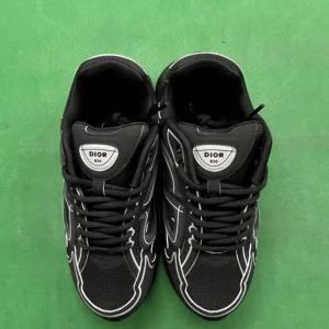 Svarta Dior B30 sneakers - Svarta Dior B30 sneakers med coola vita detaljer och reflekterande linjer längs sidorna. Skorna har meshpaneler för extra ventilation, snörning och en chunky platt sula. CD-logga på hälen och Dior-märke på tungan ger en lyxig vibe. Perfekta för dig som gillar statement sneakers.