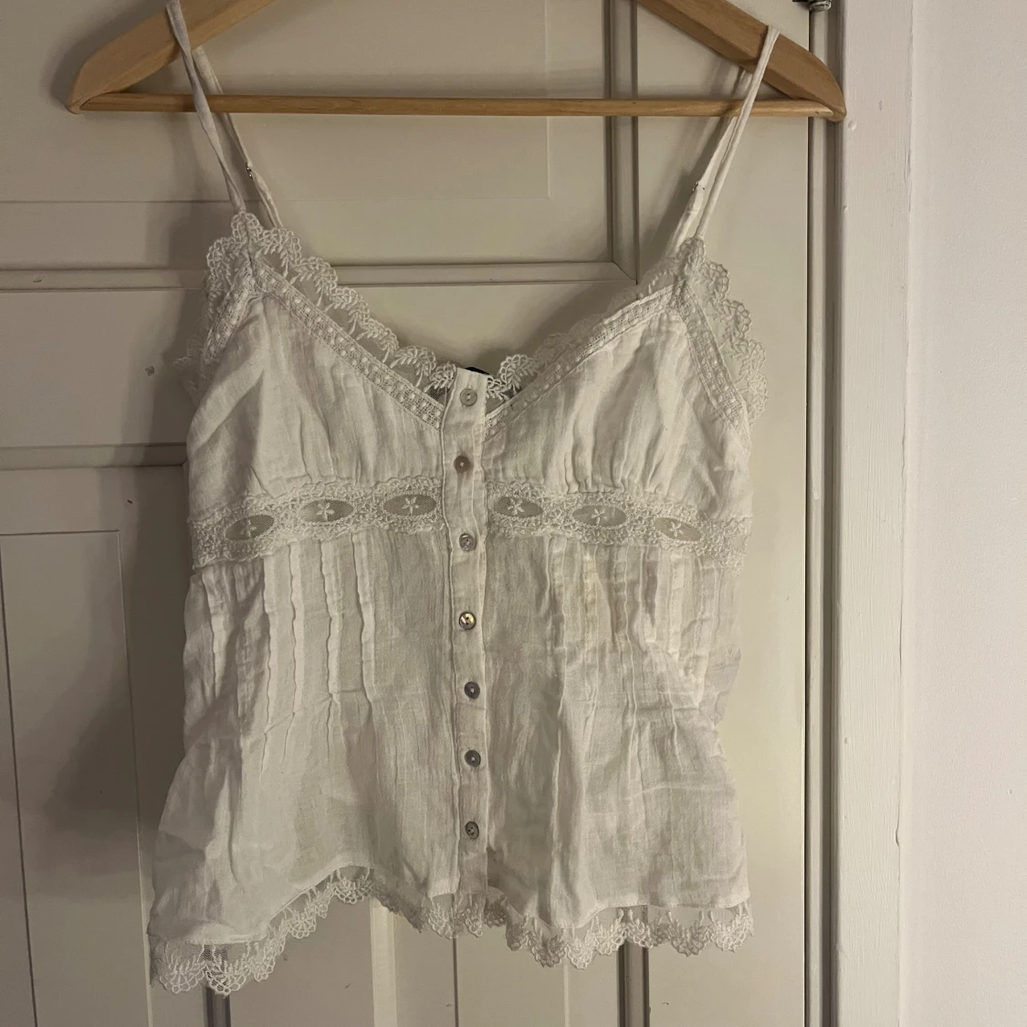 Vit linnetopp med spets och knappar