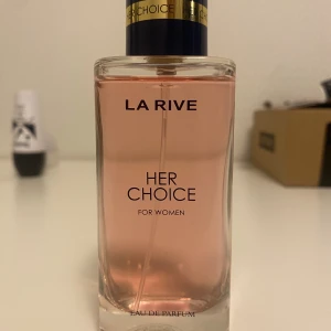 La Rive Her Choice EdP - Her Choice från La Rive är en Eau de Parfum för kvinnor med en modern vibe. Flaskan innehåller 100 ml. Perfekt för dig som vill sticka ut med en fräsch och trendig doft.