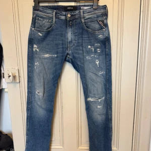 Ripped Replay Anbass slim fit jeans - Säljer ett par blå Replay Anbass jeans i slim fit med snygga slitningar och en fet wash. I princip oanvända, storlek 32/34. Hör gärna av dig vid frågor!