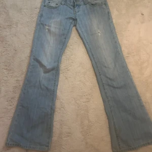 Jätte lågmidjade ljusblå jeans - Snygga lågmidjade ljusblå bootcut jeans. Säljer pga att dom blivit för små för mig! Bra skick förutom att dom är slitna längst ner vid hälen, men inga andra defekter💞Jag är 164cm och den är lite långa på mig. Midjemåttet är ca 38cm tvärs över. Passar storlek S!