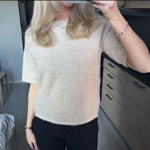 Beige stickad tröja med kort ärm - Beige stickad T-shirt från Selected Femme i storlek XS (skulle säga passformen är en stor S). Använd ett fåtal gånger, inga deffekter🤍