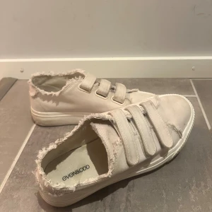 Beiga sneakers med kardborre från Even&Odd - Säljer ett par snygga beiga sneakers från Even&Odd med fransade kanter och tre breda kardborreband.