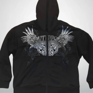 Svart zip hoodie från Southpole - Cool svart hoodie från Southpole med stort silverfärgat tryck av vingar och tribal-mönster över bröstet. Tröjan har huva, dragkedja och rymliga fickor framtill. Perfekt för dig som gillar streetwear och vill sticka ut med detaljerad design. Jesse Pinkman core.