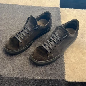 Grå sneakers från Garment Project - Säljer ett par gråa mockaskor från Garment Projekt. Skorna är använda och det finns tecken på det, bl.a fläckar i mockan där fram(se bilderna), men skorna är fortfarande fina. Hör av er vid minsta tanke💫