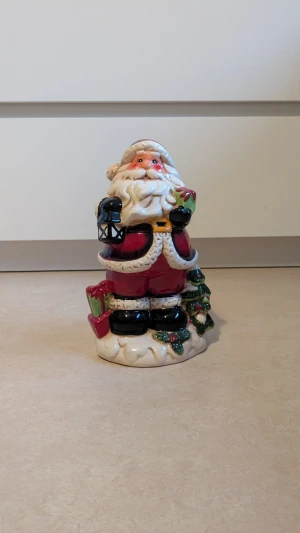 Jultomte  - Jätte fin jultomte. Jultomten är i jätte bra skick 💕. Materialet är porslin. Köpt på Guldfynd. Enligt bekräftalse från Guldfynd så är tomten gjord av porslin 