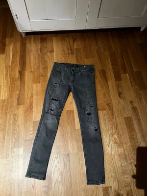 Replay grå skinny jeans med slitningar - Snygga grå jeans från Replay i modellen Luz, med skinny passform och coola slitningar på benen. Jeansen har klassisk femficksdesign, knapp och dragkedja i midjan samt detaljerade sömmar. Perfekta för dig som gillar en mix av grish och  streetstil.